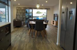 a kitchen and dining room with a table and chairs at Ulverstone Waterfront Apartments in Ulverstone