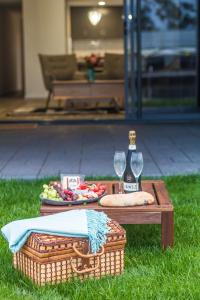a picnic table with a bottle of wine and a basket at Ulverstone Waterfront Apartments in Ulverstone
