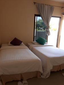 2 camas en una habitación con ventana en Classic home, en Bang Tao Beach