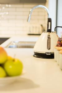 a kitchen counter with a juicer and a bowl of oranges at Ulverstone Waterfront Apartments in Ulverstone