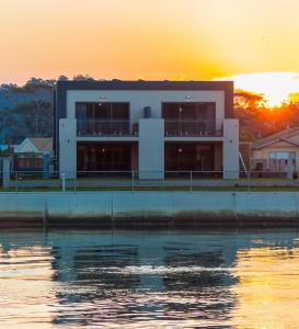 a building next to the water at sunset at Ulverstone Waterfront Apartments in Ulverstone