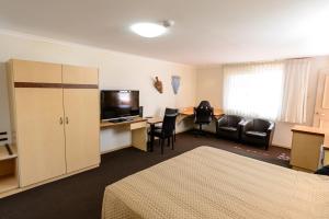 a living room with a couch and a television at Villa Mirasol Motor Inn in Bundaberg