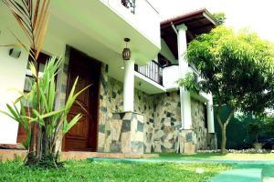 a house with a wooden door and a tree at Villa Royce in Kandy