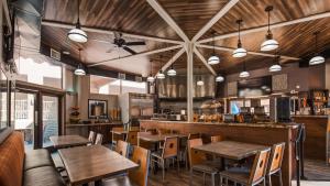 a restaurant with wooden tables and chairs and a bar at Best Western Yuma Mall Hotel & Suites in Yuma