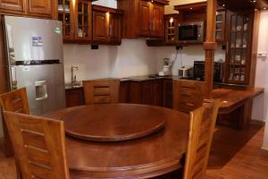 a kitchen with a wooden table and a refrigerator at Villa Royce in Kandy