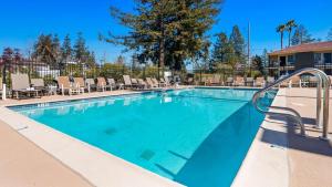 a swimming pool with chaise lounge chairs in a resort at Best Western Sonoma Winegrower's Inn in Rohnert Park