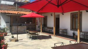 a patio with tables and chairs and red umbrellas at La Aurora in Huaraz