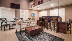 a room with a bar with chairs and a table at Best Western Inn in Merced