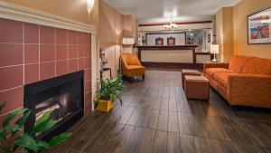 - un salon avec un canapé et une cheminée dans l'établissement Best Western Luxury Inn, à Tracy
