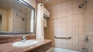 a bathroom with a shower, sink, and mirror at Best Western Plus Country Park Hotel in Tehachapi