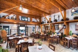 a restaurant with wooden ceilings and tables and chairs at Kalimera Hotel in Akrotiri