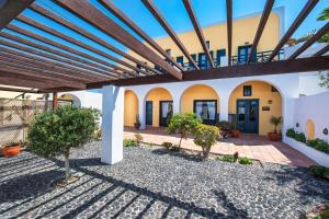 a courtyard of a house with a wooden ceiling at Kalimera Hotel in Akrotiri
