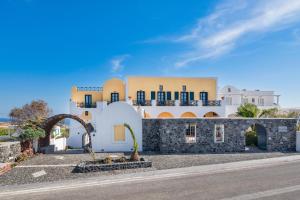 a white building with a black and white striped wall at Kalimera Hotel in Akrotiri