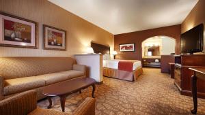 a hotel room with a couch and a bed and a television at Best Western San Dimas Hotel & Suites in San Dimas