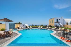 a pool with chairs and umbrellas at a resort at Kalimera Hotel in Akrotiri