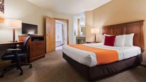 a hotel room with a bed and a desk at Best Western University Inn in Fort Collins