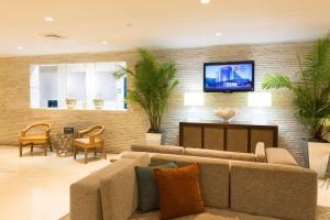 
a living room filled with furniture and a tv at Best Western Plus Atlantic Beach Resort in Miami Beach
