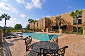 Un patio con mesa y sillas junto a una piscina. en Best Western Plus Madison, en Madison
