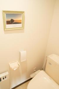 baño con aseo y una foto en la pared en Guest House COCO, en Lago Toya