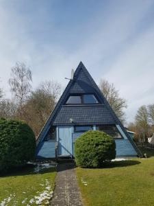 una casa azul con techo de gambrel en Ferienhaus Familie Mischkies, en Damp