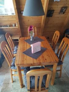 - une table en bois avec des chaises et une boîte dans l'établissement Ferienhaus Familie Mischkies, à Damp