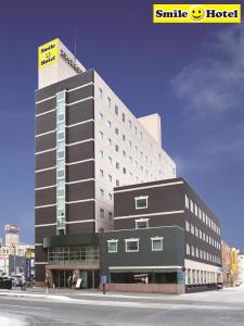 ein großes Gebäude an der Ecke einer Straße in der Unterkunft Smile Hotel Asahikawa in Asahikawa