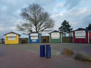 a row of colourfulsheds in a parking lot at Ferienhaus Familie Mischkies in Damp +8 photos