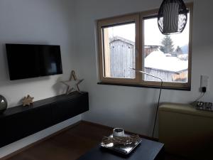 salon z telewizorem i oknem w obiekcie Haus Riefli- Monique w mieście Sankt Anton am Arlberg +8 zdjęć