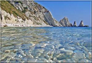 a view of a beach with rocks in the water at Hotel "Il Parco" B&B Sirolo in Sirolo