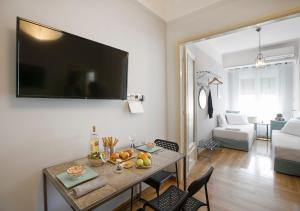 a living room with a table with a television on the wall at Attractive Flat near the Acropolis Museum & Metro Station by Athenian Homes in Athens