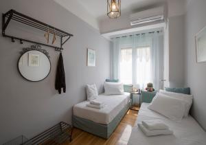 um quarto com uma cama, um espelho e um sofá em Attractive Flat near the Acropolis Museum & Metro Station by Athenian Homes em Atenas