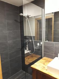 a bathroom with a shower with black tiles at Haus Riefli- Monique in Sankt Anton am Arlberg