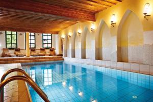 a pool in a building with a swimming pool at Hotel Unterbrunn Apartments & Gästehaus in Neukirchen am Großvenediger