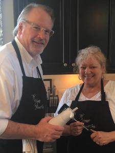 un hombre y una mujer de pie en una cocina sosteniendo una batidora en The Wynne House Inn, en Holly Springs