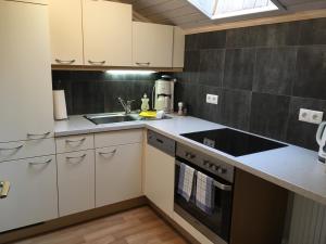 a kitchen with white cabinets and a sink at Haus Latschenheim in Ramsau am Dachstein +14 photos
