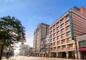 una strada di città con edifici alti su una strada di Green World Triple Beds a Taipei
