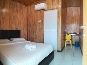 um quarto com uma cama e uma cadeira amarela em Mabohai Resort Klebang em Malaca