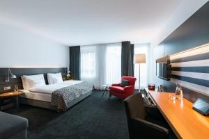 
a hotel room with two beds and a television at THE MADISON Hotel Hamburg in Hamburg
