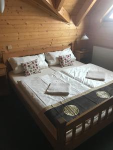 a large bed in a room with a wooden wall at Penzion Haltmar in Ostružná