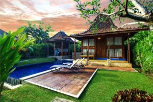 a garden with two chairs and a house at Ubud Heaven Penestanan in Ubud