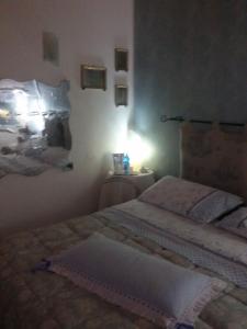 a bedroom with two beds and a light on the wall at Bed And Breakfast Di Manu in Taglio di Po