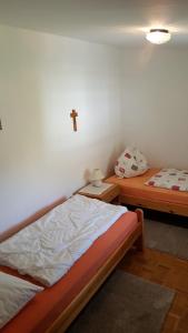 een slaapkamer met 2 bedden en een kruis aan de muur bij Ferienwohnung Angelika in Schruns