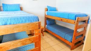 a bedroom with two bunk beds with blue sheets at Stella Maris in Amanzimtoti