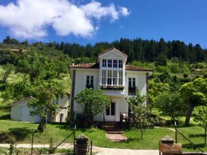 a large white house with trees in the background at Villa Elena in Potes