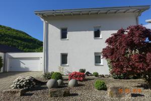 una gran casa blanca con un patio con flores en Ferienwohnung Himmlingen, en Aalen