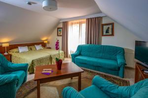 a hotel room with a bed and a couch and a table at Betekints Wellness Hotel in Veszprém