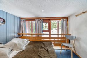 a bedroom with a bed and a window and a chair at Résidences quartier Charmettoger - maeva Home in Arc 1800