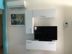 A television and/or entertainment centre at Tempo Di Sole con Serv Spiaggia