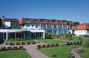 a resort with chairs and a building in the background at Hotel Heinz in Höhr-Grenzhausen