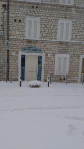 a brick building with a door in the snow at Affittacamere le Tre Sorelle in Sirolo